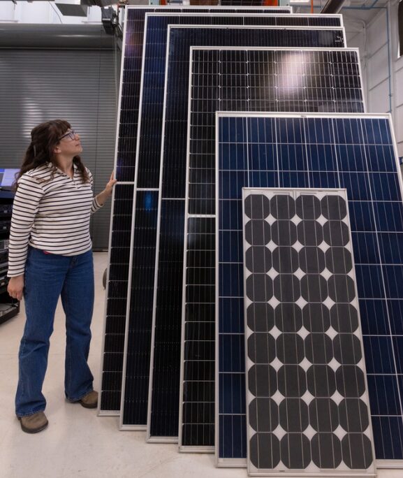 NREL researcher Elizabeth Palmiotti alongside modules.